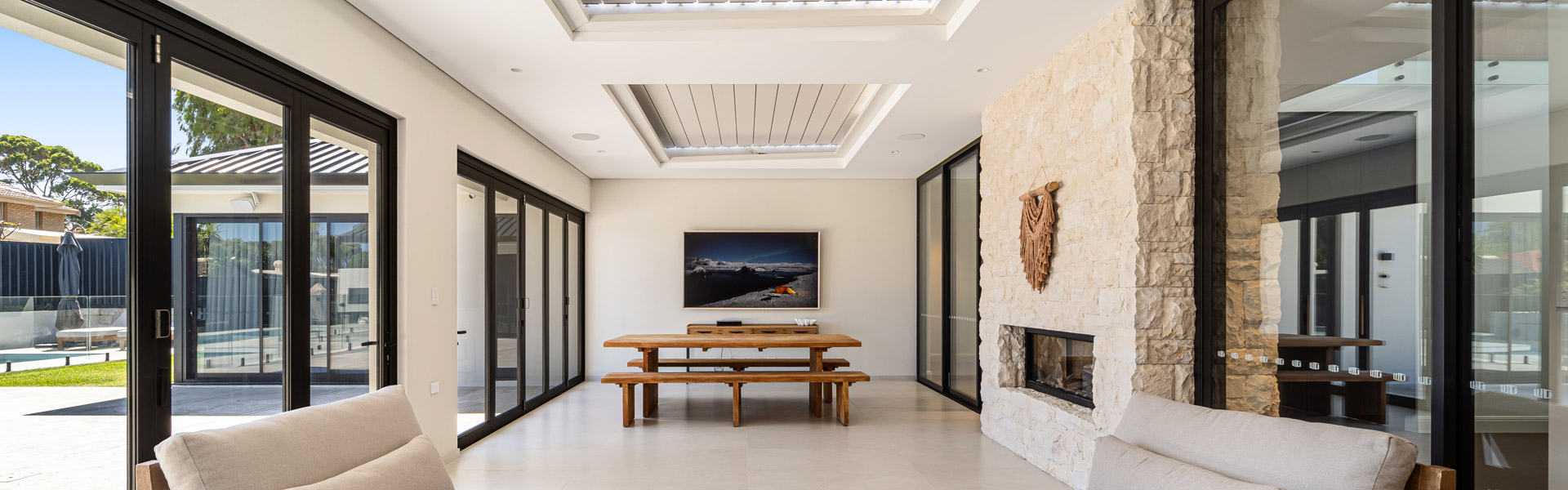 Enclosed patio with fireplace and table leads out to stunning entertainment area