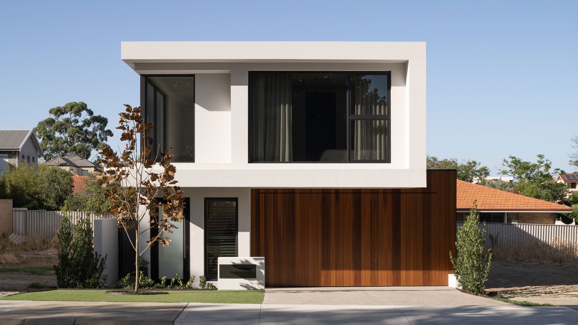 Front view of a modern two storey home with timber garage door in Applecross