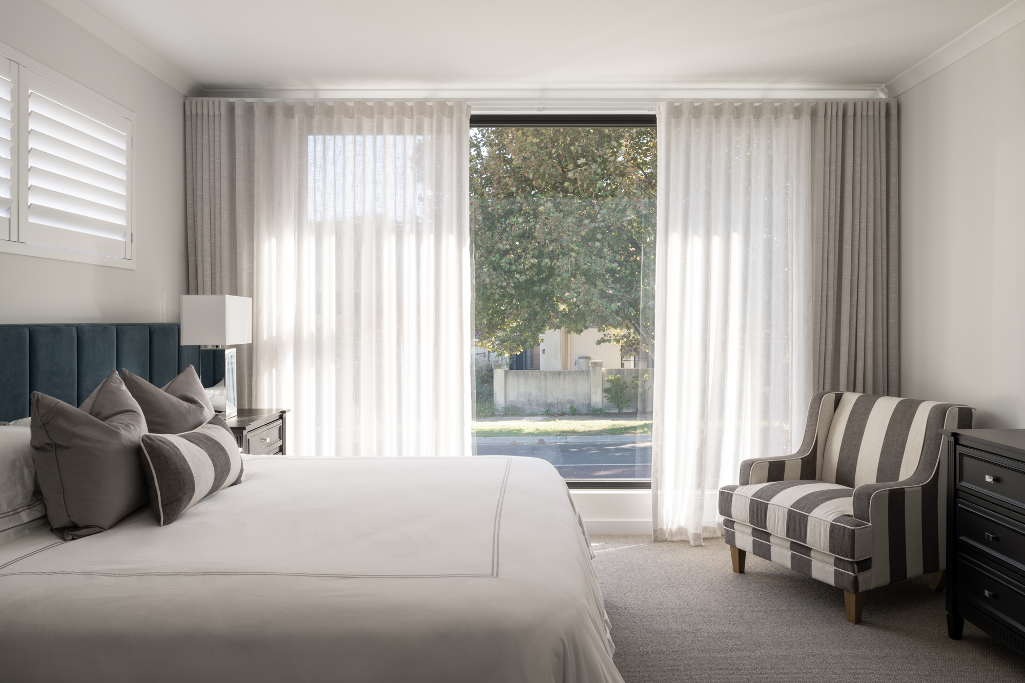 Main bedroom with upholstered bedhead and floor to ceiling window in Applecross