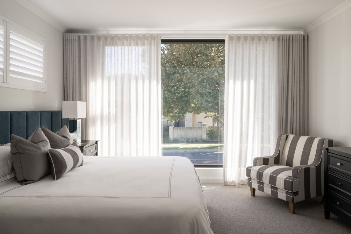 Main bedroom with upholstered bedhead and floor to ceiling window in Applecross