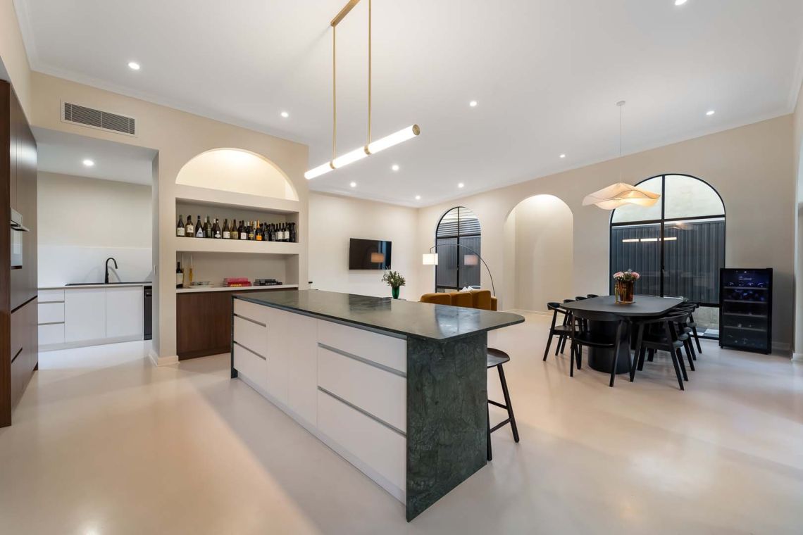 Open plan kitchen with green stone island and arched windows in Fremantle