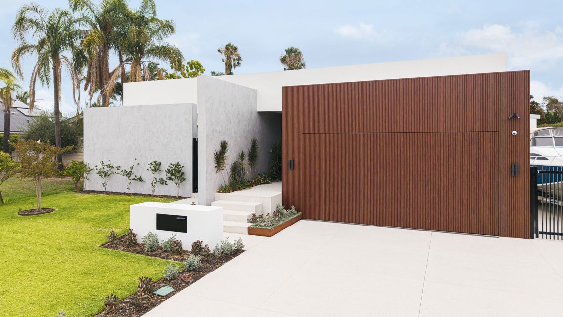 Single storey home with timber clad garage and palm trees in Attadale