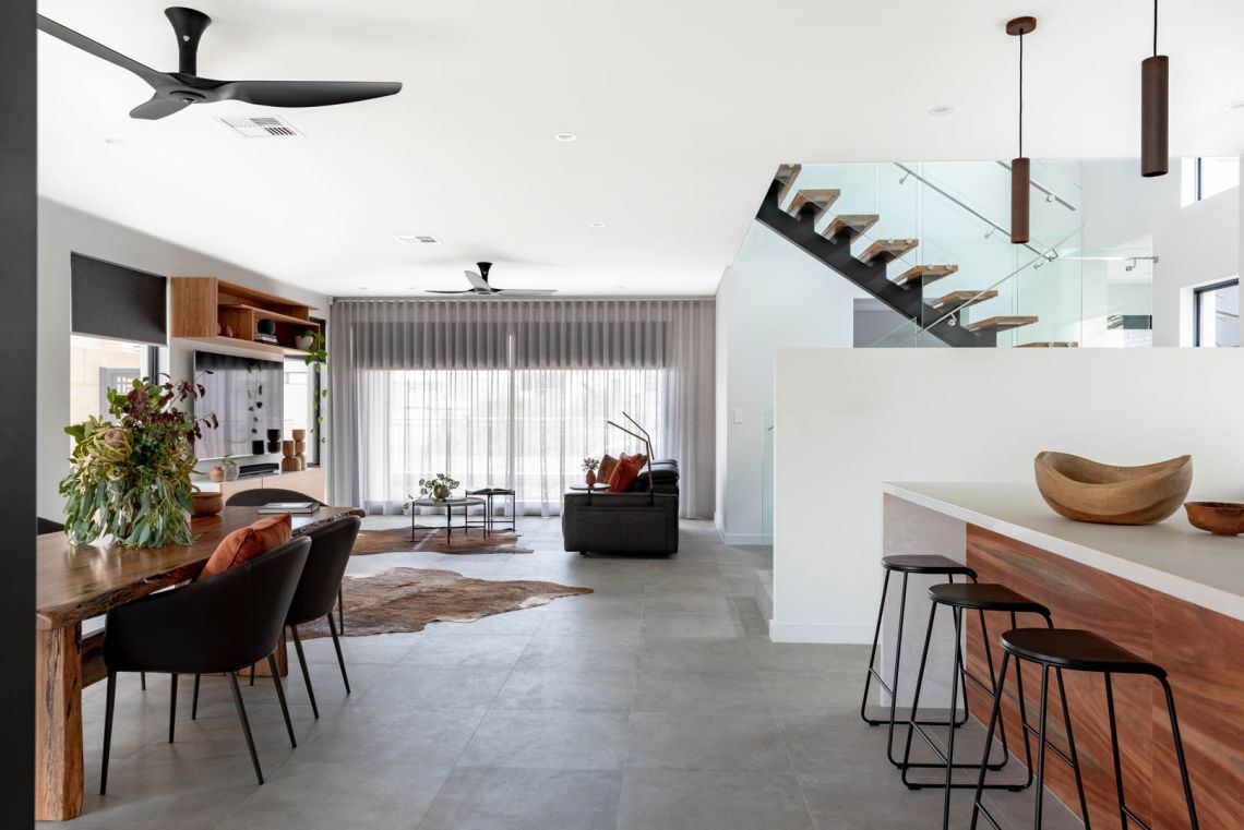 Open plan living and dining with floating timber staircase in Mindarie