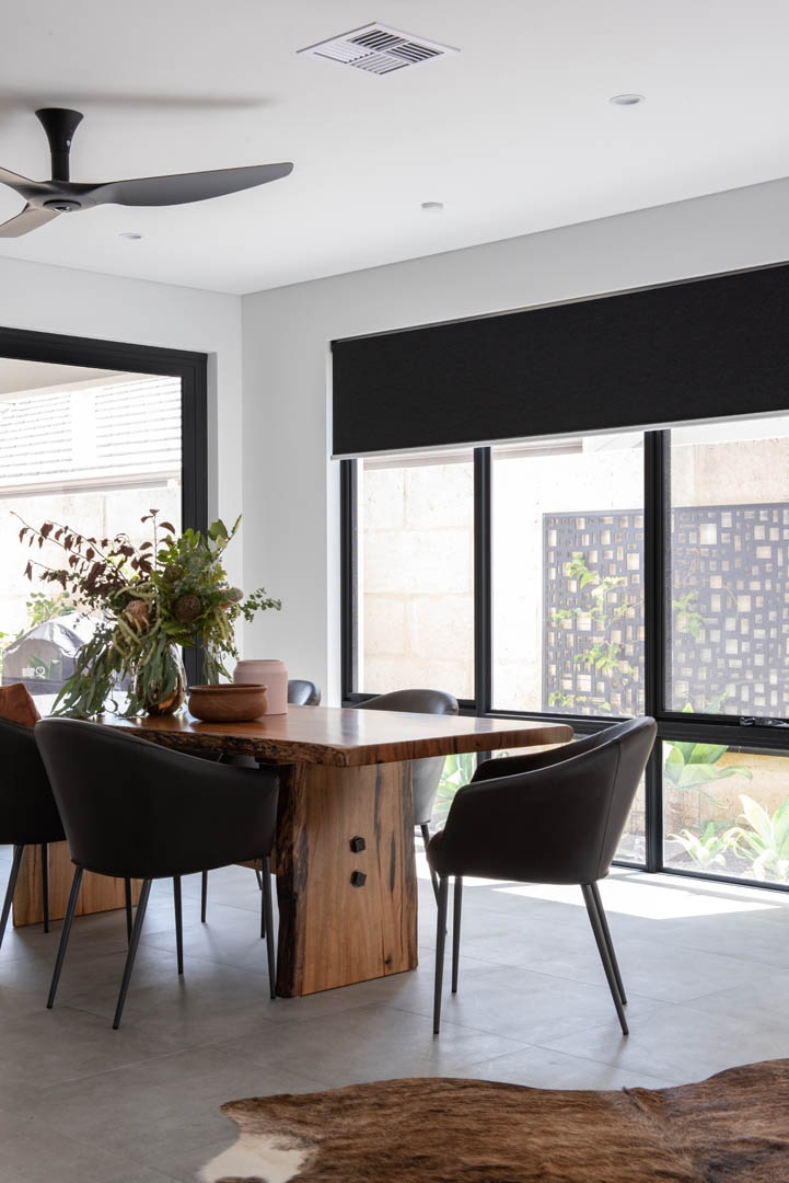 Dining area with live edge timber table and black chairs in Mindarie