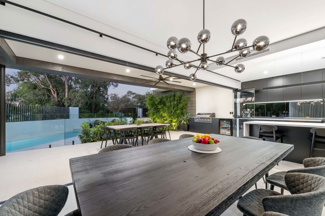 Indoor outdoor dining area opening to the pool and outdoor kitchen in Attadale