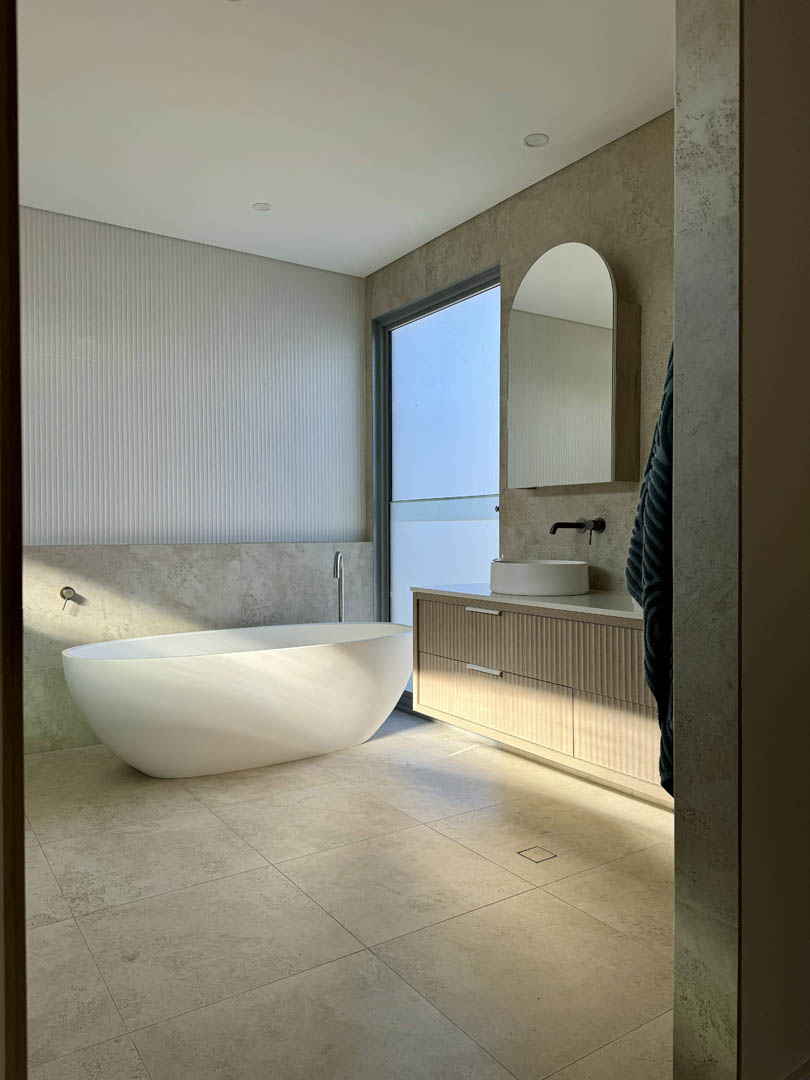 Bathroom with freestanding bath and fluted timber vanity in City Beach