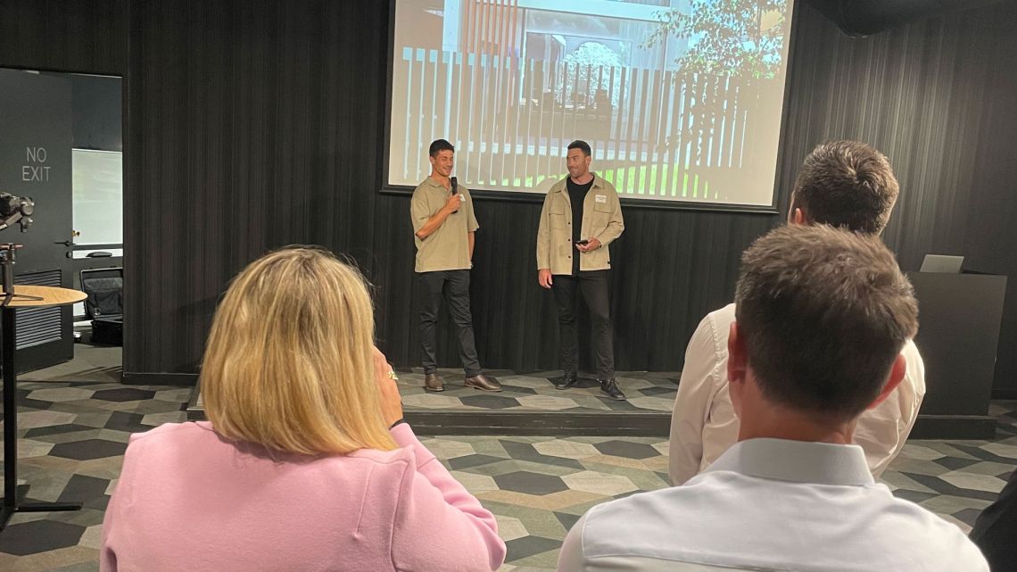 Two presenters speaking to guests at the Timeless event