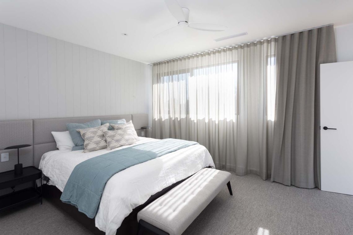 Bedroom with upholstered bedhead and sheer curtains in Floreat