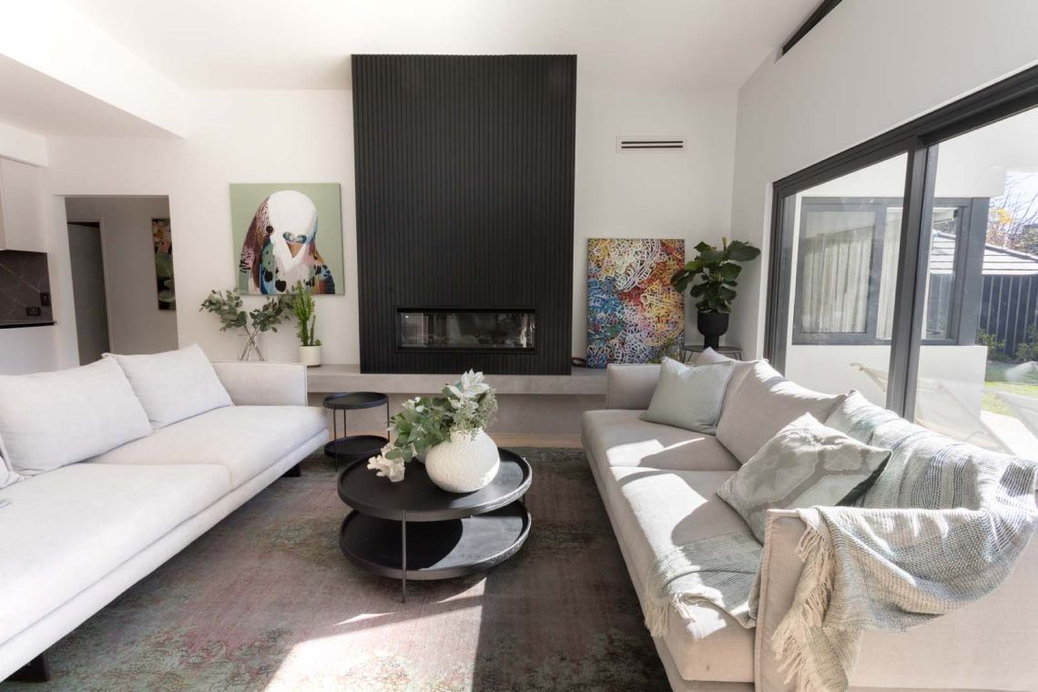 Living room with black fluted fireplace wall and two sofas in Floreat