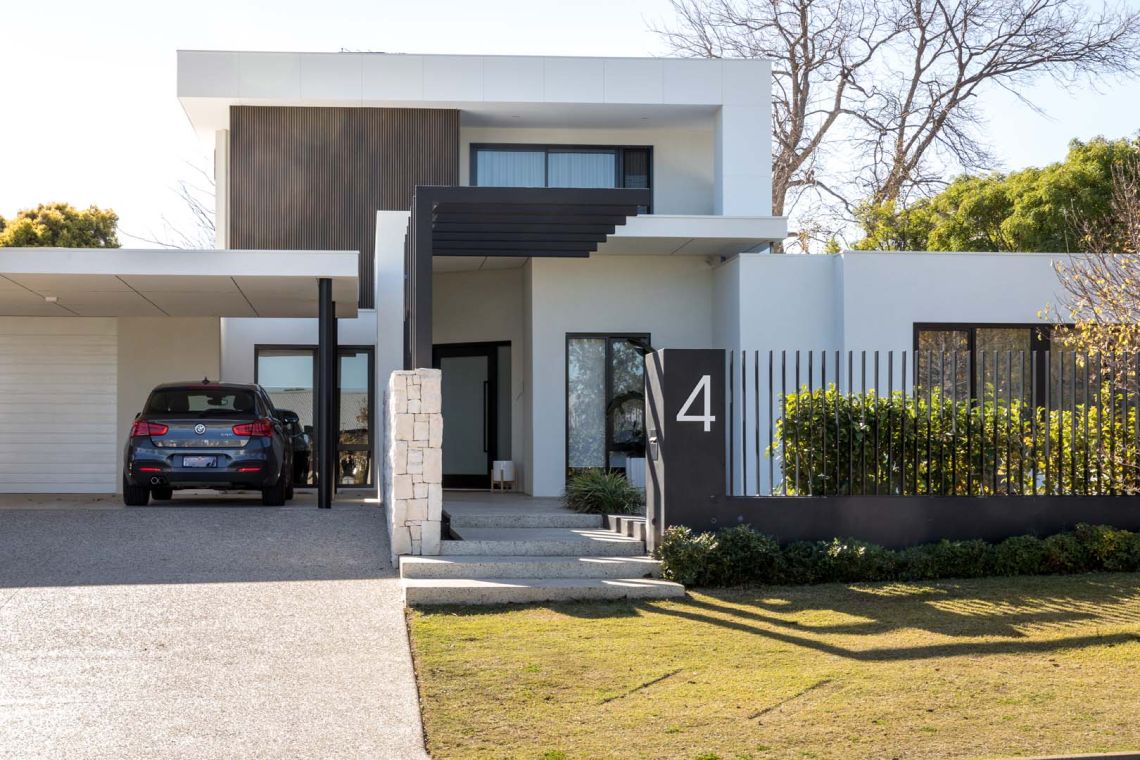 Modern single storey home with carport and slatted fence in Floreat