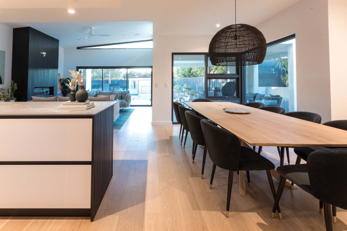 Dining table with woven pendant beside the kitchen island in Floreat