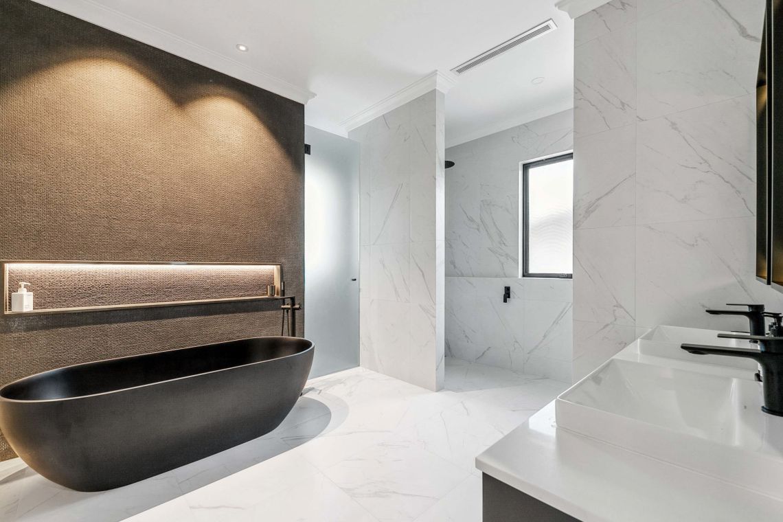 Ensuite with black freestanding bath and marble look tiles in Attadale