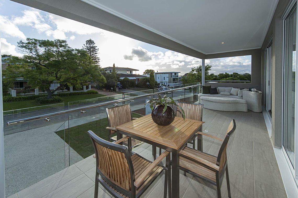 Covered balcony with timber dining setting and street views in Ardross
