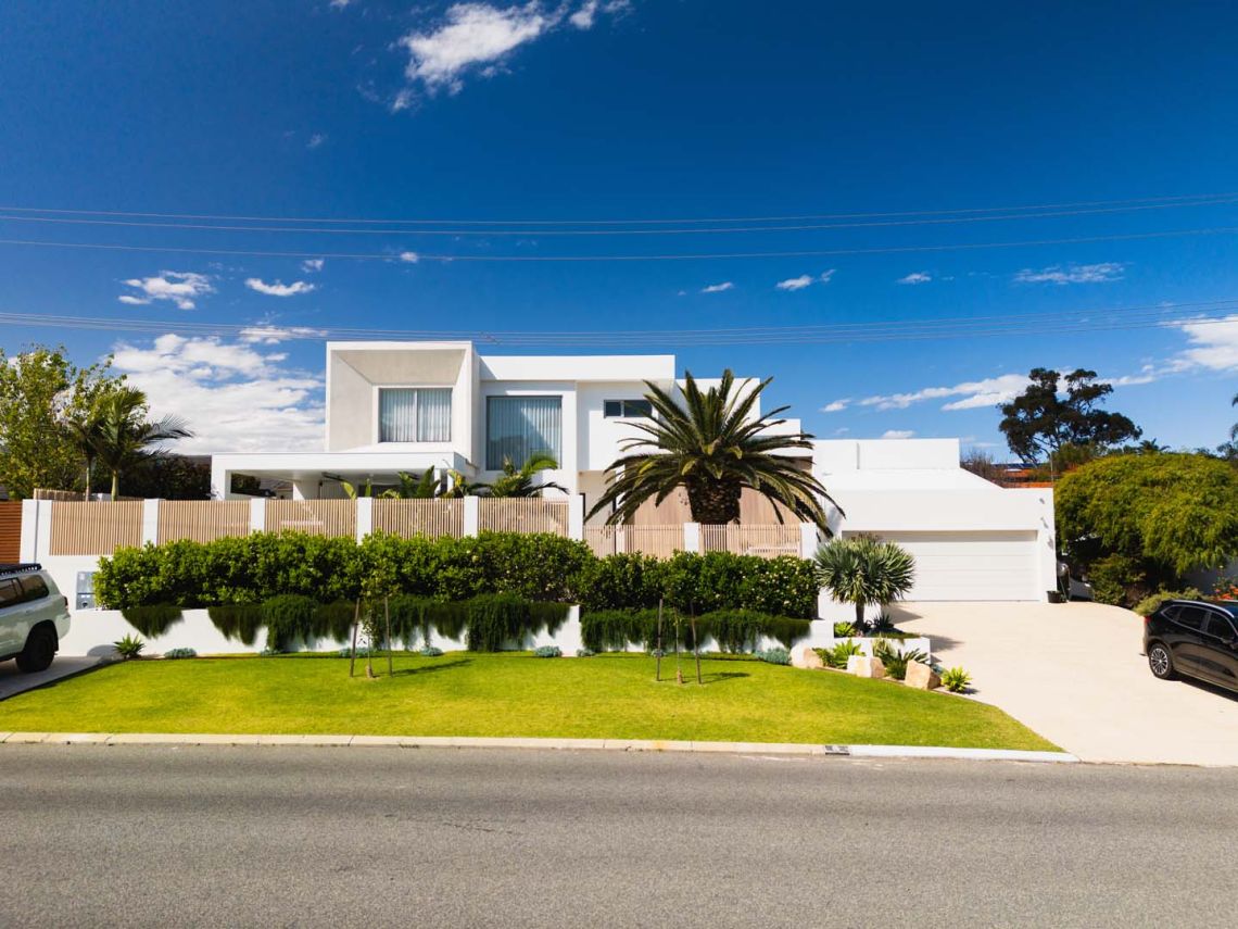 Street view of a white two storey home with landscaped front garden in City Beach