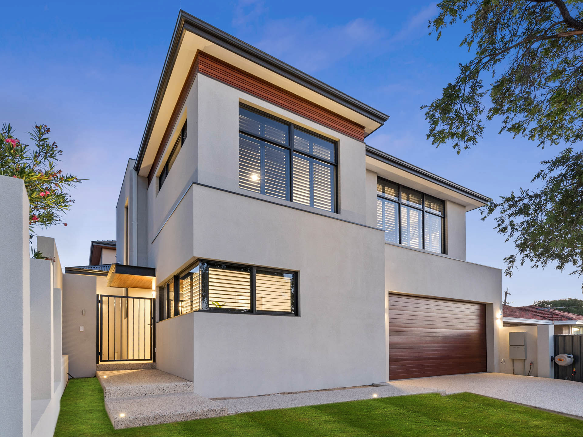 Two storey rendered home with timber fascia at dusk in Tuart Hill