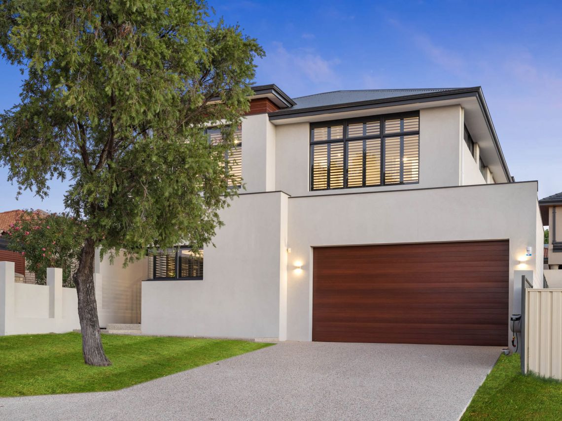 Two storey rendered home with timber garage door in Tuart Hill